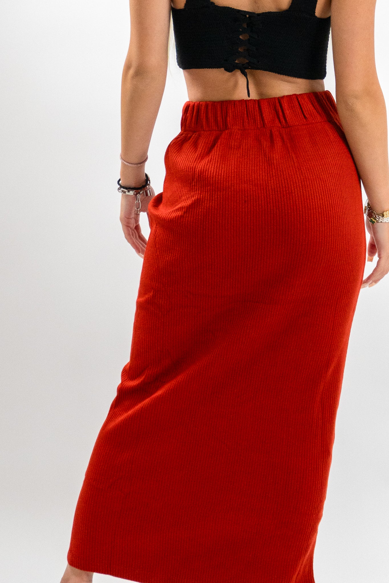 Κοντινή λεπτομέρεια της κόκκινης μάξι φούστας Solenya από πίσω — με ελαστική μέση και rib υφή, ιδανική για κομψές εμφανίσεις στο γραφείο ή απογευματινά ραντεβού.
