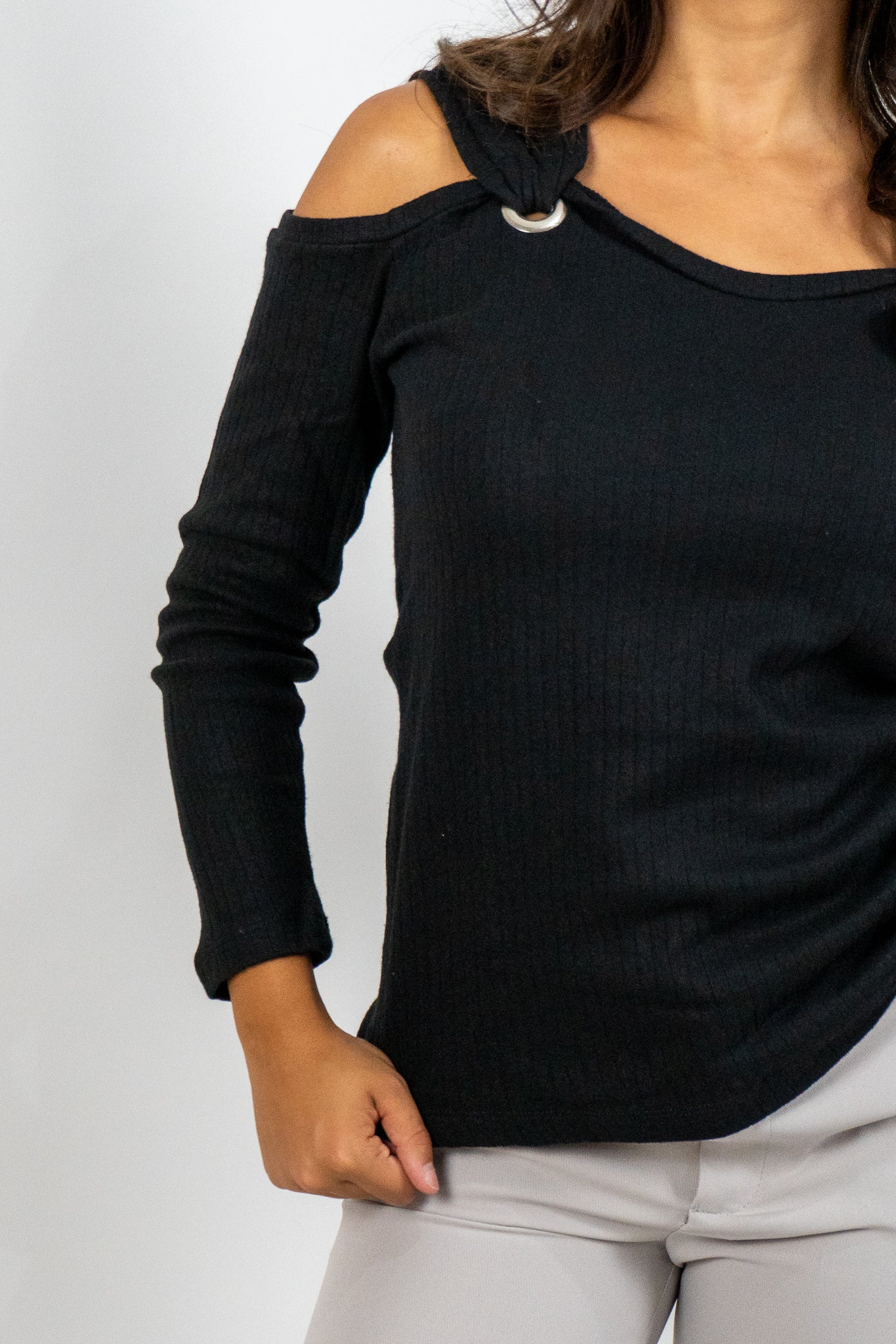 Black long-sleeve top with shoulder cutouts worn by a person on a white background