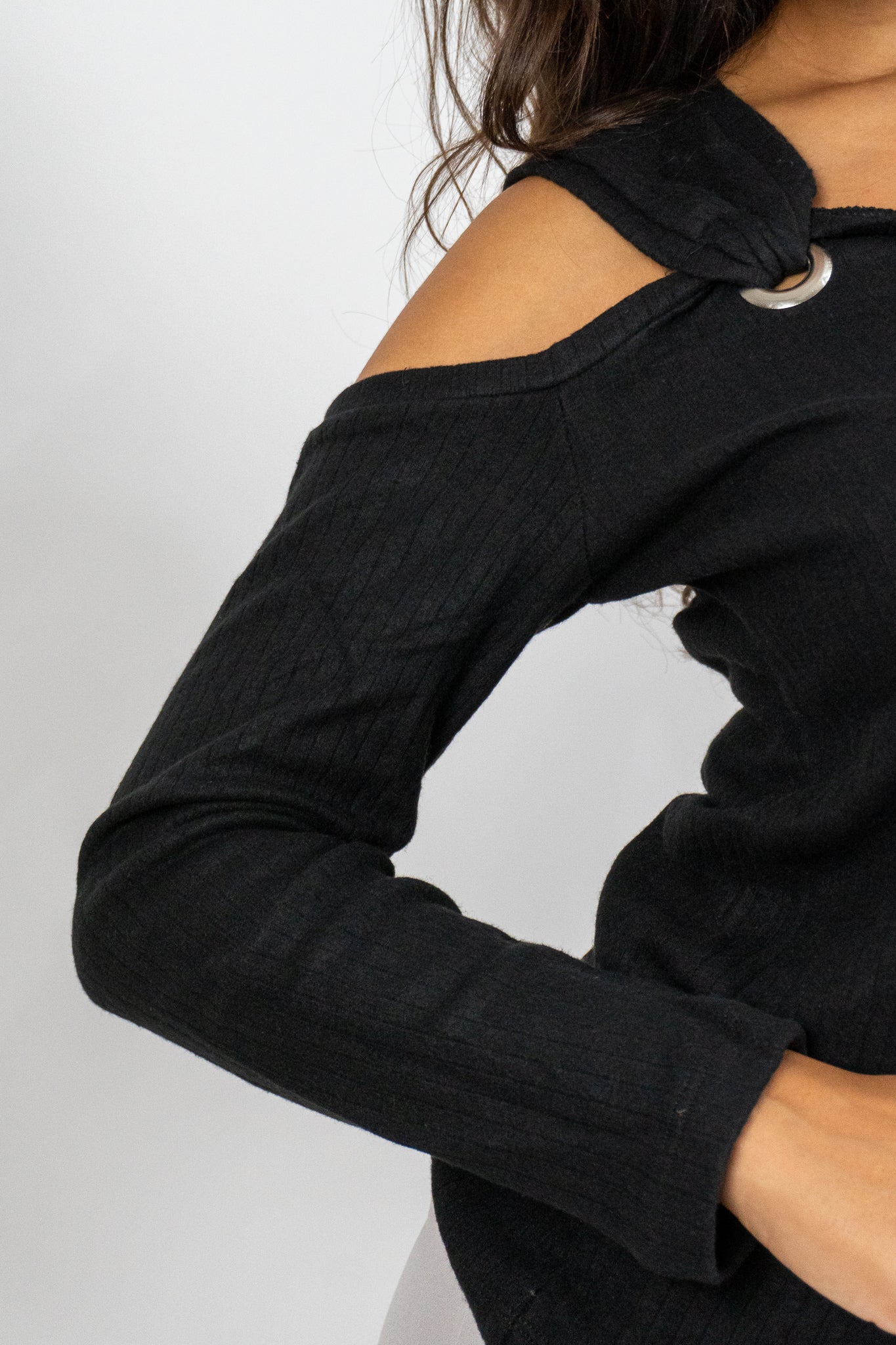 Black long-sleeve top with shoulder straps on a white background