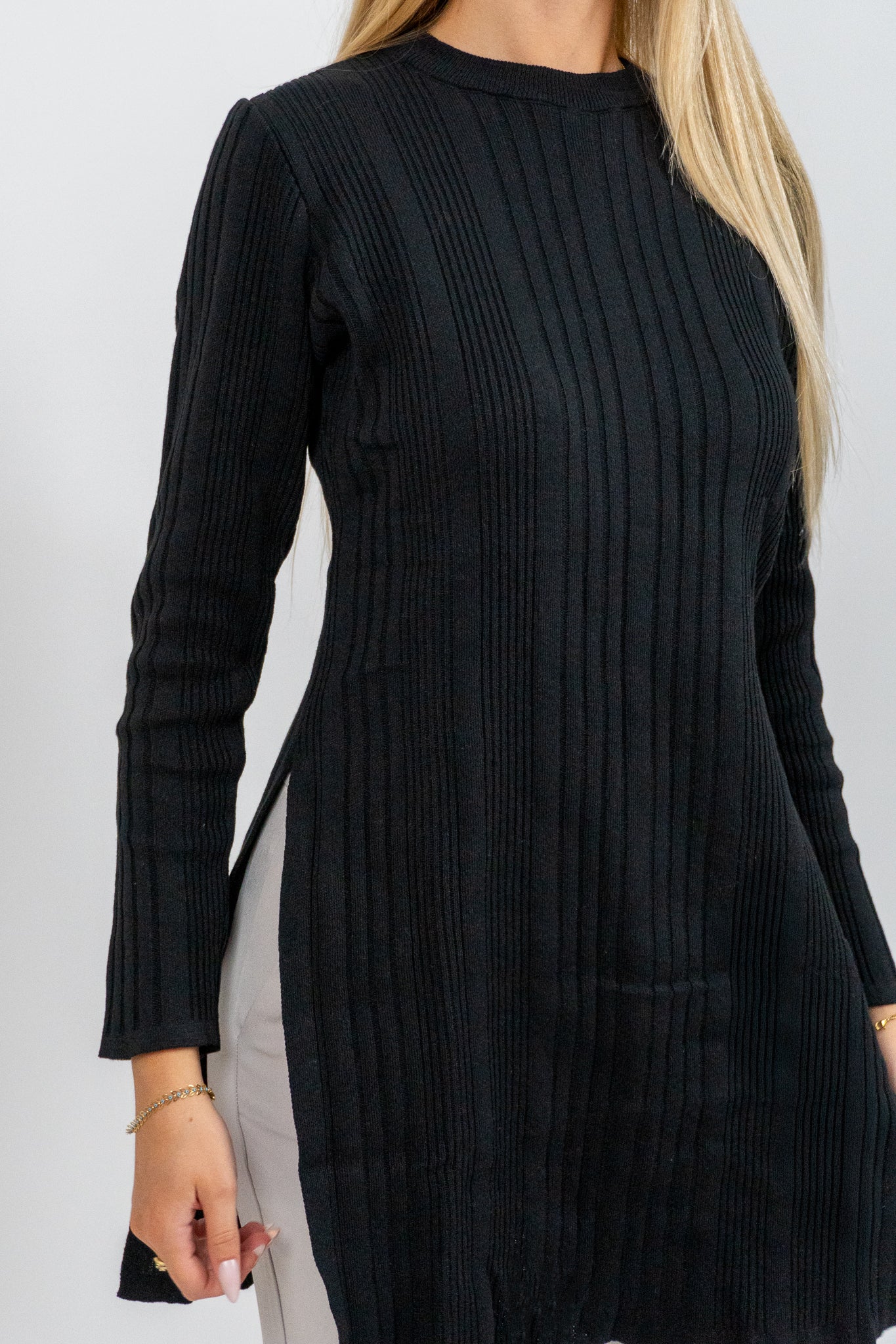 Black ribbed dress worn by a person on a white background