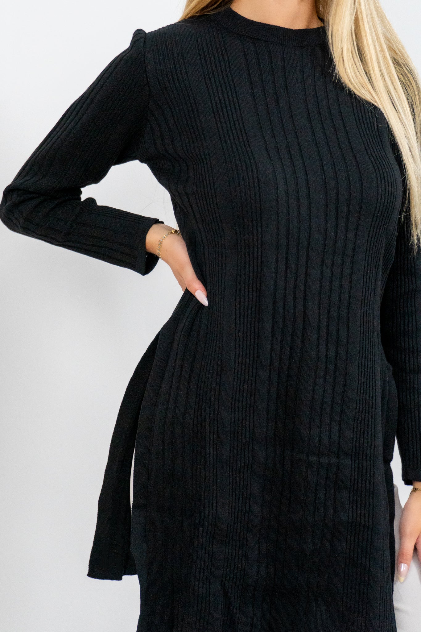 Black ribbed dress worn by a person on a white background