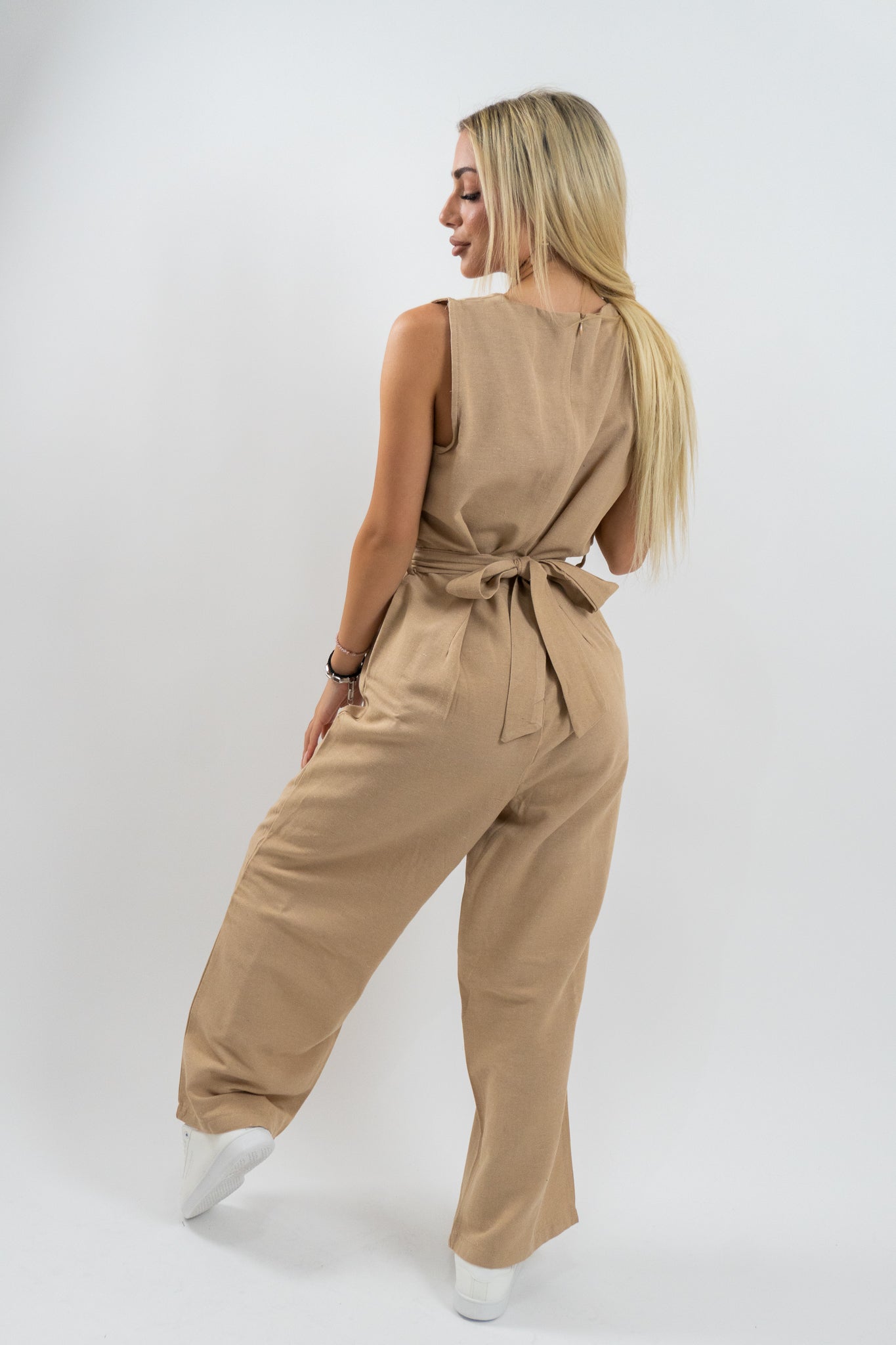 Η πλευρική όψη της μπεζ φόρμας Waist Belt αναδεικνύει την εφαρμογή και την ευελιξία του υφάσματος, ιδανικό ρούχο για καθημερινή κομψότητα με άνεση.